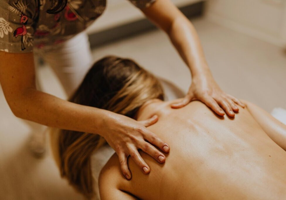 two hands massaging woman's back