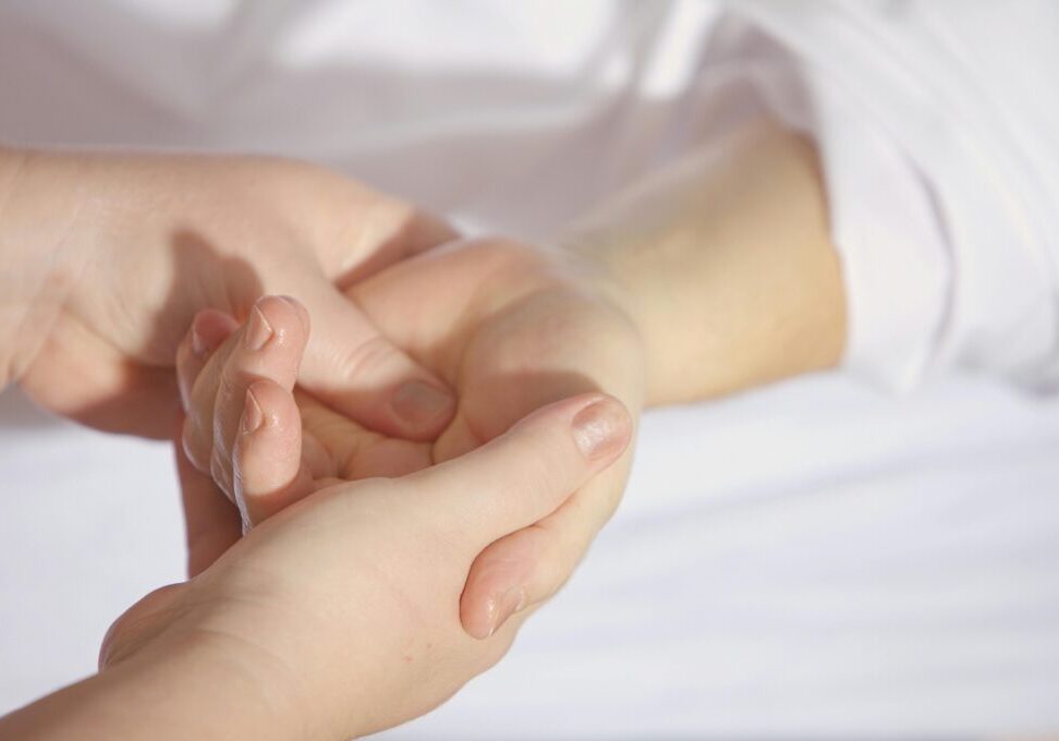 two hands massaging a different person's hand